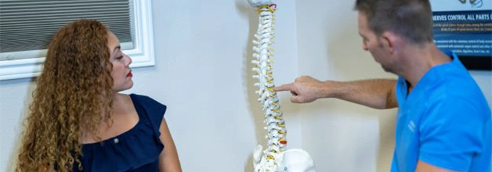 Chiropractor Dan Foss Pointing To Spine